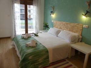 Un dormitorio con una cama grande con toallas. en Masquestar Rías Altas, en Foz 40 fotos más