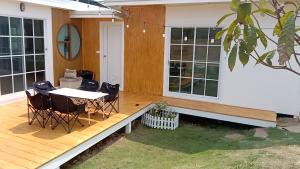 a porch of a house with a table and chairs at บ้านไร่ฟ้าสวย Nordic 02 in Ban Kom