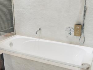 a white bath tub with two faucets in a bathroom at Hotel MC San José in San José