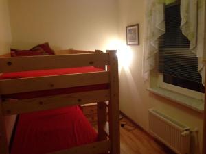 a bedroom with a bunk bed and a window at Ferienhaus in einer Feriensiedlung auf dem Eichenberg mit Terrasse und Grill in Michaelstein