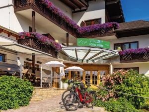 una bicicletta rossa parcheggiata di fronte a un edificio di VitalZeit Hotel Weber a Bad Schönau