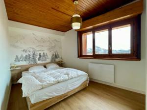 ラルプ・デュエズにあるHomency - Résidence La Meije 9のベッドと大きな窓のある寝室