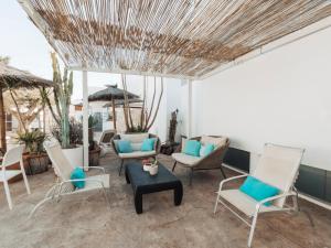 a patio with white chairs and a table at Hotel MC San José in San José