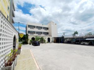 a parking lot in front of a white building at SUKANO Apartment VIP in Ban Khlong Chao +34 photos