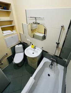a bathroom with a sink and a toilet and a tub at Iren Politech apartment in Lviv +4 photos