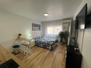 a bedroom with a bed and a desk and a table at Roger Apartamentos in Cambrils
