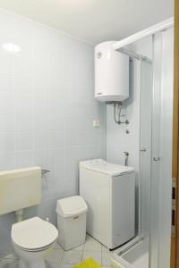 a white bathroom with a toilet and a sink at Wohnung in Zambratija mit Gemeinsamem Grill in Zambratija