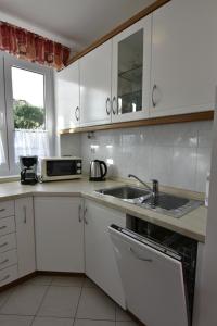 a white kitchen with a sink and a microwave at Wohnung in Zambratija mit Gemeinsamem Grill in Zambratija +14 photos