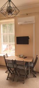 a dining room table with chairs and a flat screen tv at First Hotel's apartment in Juodkrantė