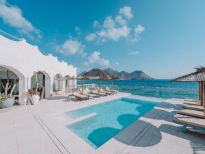 a pool with chairs and the ocean in the background at Villa Singular in San José