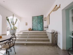 a staircase in a white room with a green door at Villa Singular in San José