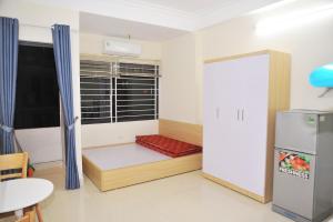 Kleines Zimmer mit einem Bett und einem Kühlschrank. in der Unterkunft nhatroduytan in Hanoi