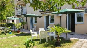 een groep stoelen en parasols voor een huis bij Garden Rooms Chiara in Poreč