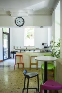 a room with tables and chairs and a clock on the wall at Ethic étapes le Cart in Sommières