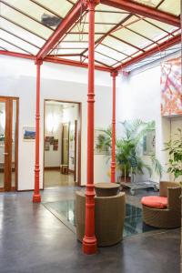 a lobby with red columns and chairs and plants at Ethic étapes le Cart in Sommières +27 photos