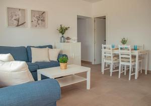 a living room with a blue couch and a table at MojacarProperty, Casa Luisa 1ª Línea de Playa in Mojácar