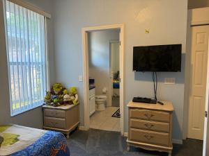 a bedroom with a bed and a television on the wall at Shrek's Hideout! - 5 min from Disney! in Kissimmee