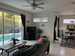 a living room with a couch and a tv and a table at Shrek's Hideout! - 5 min from Disney! in Kissimmee