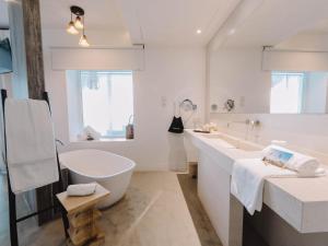 a white bathroom with a tub and a sink at Villa Singular in San José