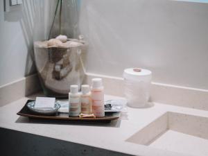a tray with four bottles of cosmetics on a counter at Villa Singular in San José
