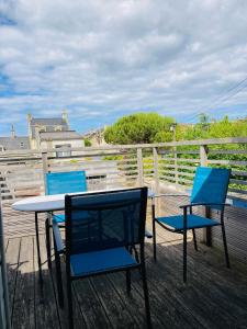 a patio with two chairs and a table on a deck at Joli F2 avec terrasse 150m plage in Saint-Aubin-sur-Mer