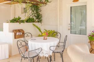a table with chairs and a vase of flowers on it at Dimora Tauro B&B in Fasano