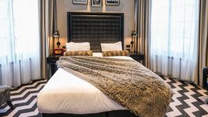 a bedroom with a large bed with a blanket at Hotel Gotham in Manchester