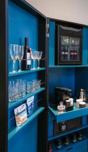 a pantry with blue shelves with wine glasses at Hotel Gotham in Manchester