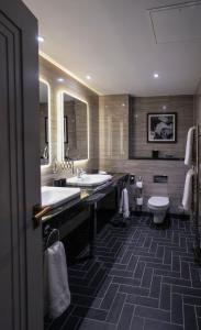 a large bathroom with two sinks and a toilet at Hotel Gotham in Manchester
