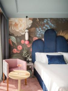 a bedroom with a bed and a chair and a table at Hotel Antik San Sebastián in Donostia-San Sebastián
