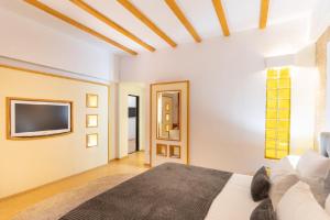 a bedroom with a bed and a tv on the wall at Villa Pontica in Mamaia Sat/Năvodari