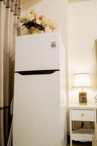 ein weißer Kühlschrank mit Gefrierfach neben einem Tisch mit einer Lampe in der Unterkunft Let You inn in Surabaya