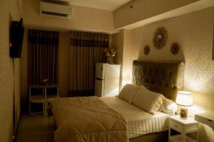 ein Schlafzimmer mit einem weißen Bett und einem Kühlschrank in der Unterkunft Let You inn in Surabaya + 12 Fotos