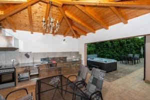 an open kitchen and dining room with wooden ceilings at Villa Buroli with Pool, Sauna and Jacuzzi in Buroli