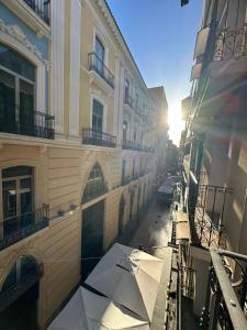 einen Blick vom Balkon eines Gebäudes mit Sonnenschirm in der Unterkunft Calle Mayor GAM in Alicante