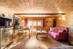 a living room with a couch and a table at "CHALET dei FIORI" room & apartment in Bedretto