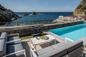 basen z krzesłami i stołem oraz ocean w obiekcie Made By The Sea Villas 8 BDRM w mieście Ligaria