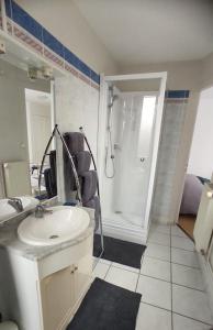 Un baño blanco con lavabo y ducha. en Escapade en bord de mer, en Dunkerque