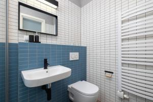 a blue and white bathroom with a sink and a toilet at 2 bedroom apartment Św Jana - Main Square in Kraków