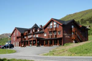 um grande edifício de madeira ao lado de uma estrada em Vossestrand Hotel and Apartments em Myrkdalen