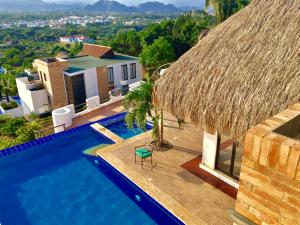 a villa with a swimming pool and a straw roof at Espectacular Casa de Descanso en Anapoima in Anapoima