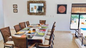 a dining room with a table with chairs and a mirror at Espectacular Casa de Descanso en Anapoima in Anapoima