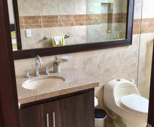 a bathroom with a sink and a toilet and a mirror at Espectacular Casa de Descanso en Anapoima in Anapoima +30 photos