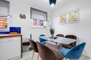 a dining room with a glass table and chairs at Delightful 4 bedroom House Thamesmead West From 360stays in North Woolwich