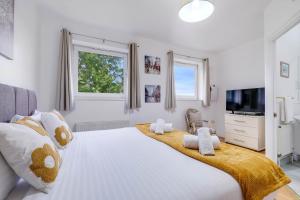 a bedroom with a large white bed with towels on it at Delightful 4 bedroom House Thamesmead West From 360stays in North Woolwich