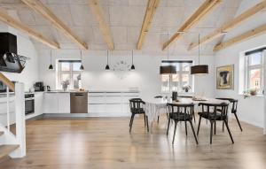 スケーエンにある4 Bedroom Cozy Home In Skagenのテーブルと椅子のあるキッチンとダイニングルーム
