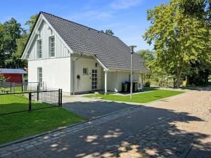 a white house with a gambrel roof at CBlue: Seeblick, Kamin, Wallbox, Natur in Bentwisch