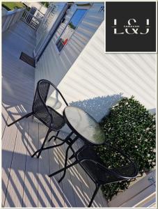 una silla negra sentada en un porche junto a un arbusto en L&J Caravan Skegness, en Chapel St. Leonards