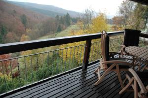 a rocking chair on a balcony with a view of the mountains at Ferienhaus Schanze19 in Schmallenberg +1 photo