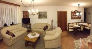 a living room with two couches and a table at Großzügige Ferienwohnung für 5 Personen mit überdachter Terrasse und wundervollem Garten mit Koi-Teich in Waldnähe in Marktredwitz